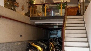Un intérieur moderne avec un escalier menant à un deuxième étage, une fresque murale et une moto garée dans un coin.