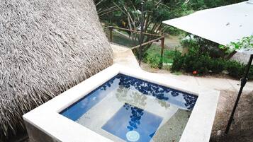 Uma piscina retangular com água azul límpida, rodeada por uma borda de concreto.