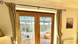 Una habitación con puerta corrediza de vidrio que da a un patio, un radiador y una lámpara.