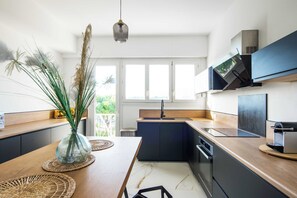 A modern kitchen with a wooden countertop, a built-in stove, and a large window.