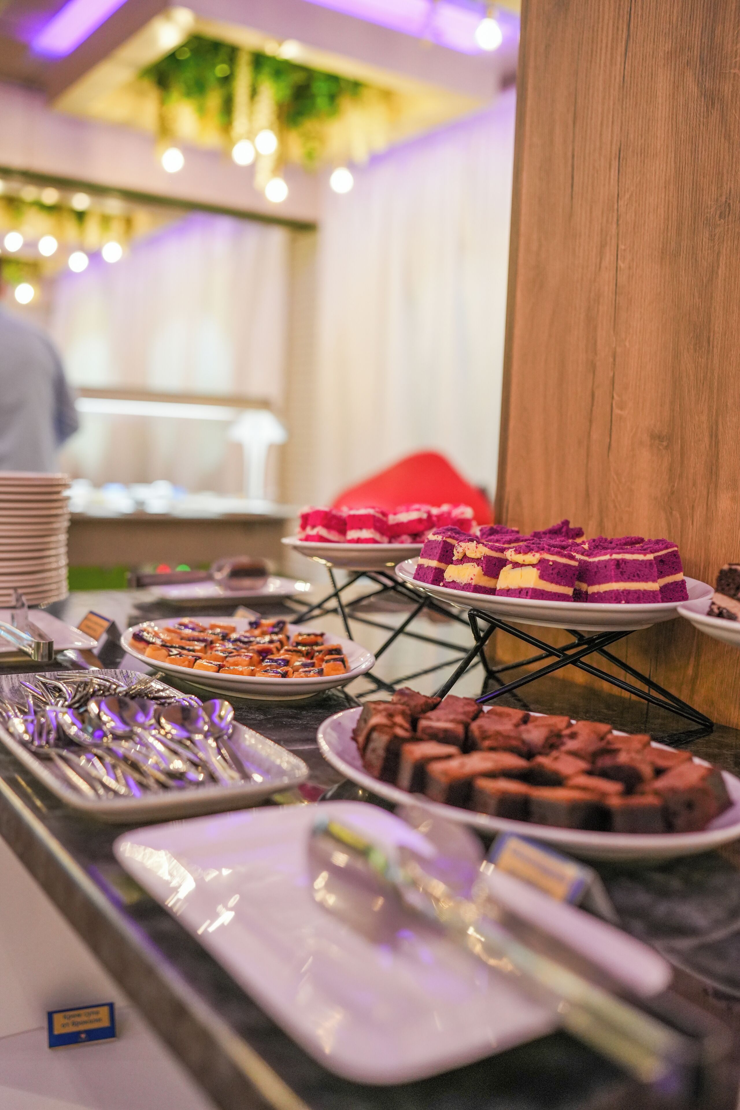 Una mesa de buffet con diversos postres y cubiertos.