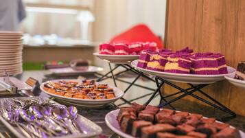 Una mesa de buffet con diversos postres y cubiertos.