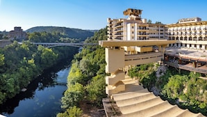 Un hotel de varios pisos, con un río al fondo y un puente.
