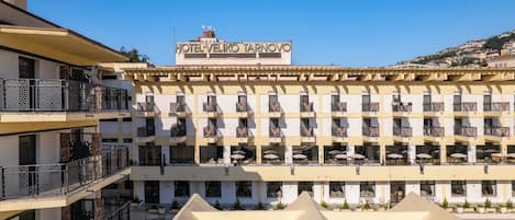 Un hotel con varios balcones, mobiliario exterior y vistas despejadas de los edificios circundantes.