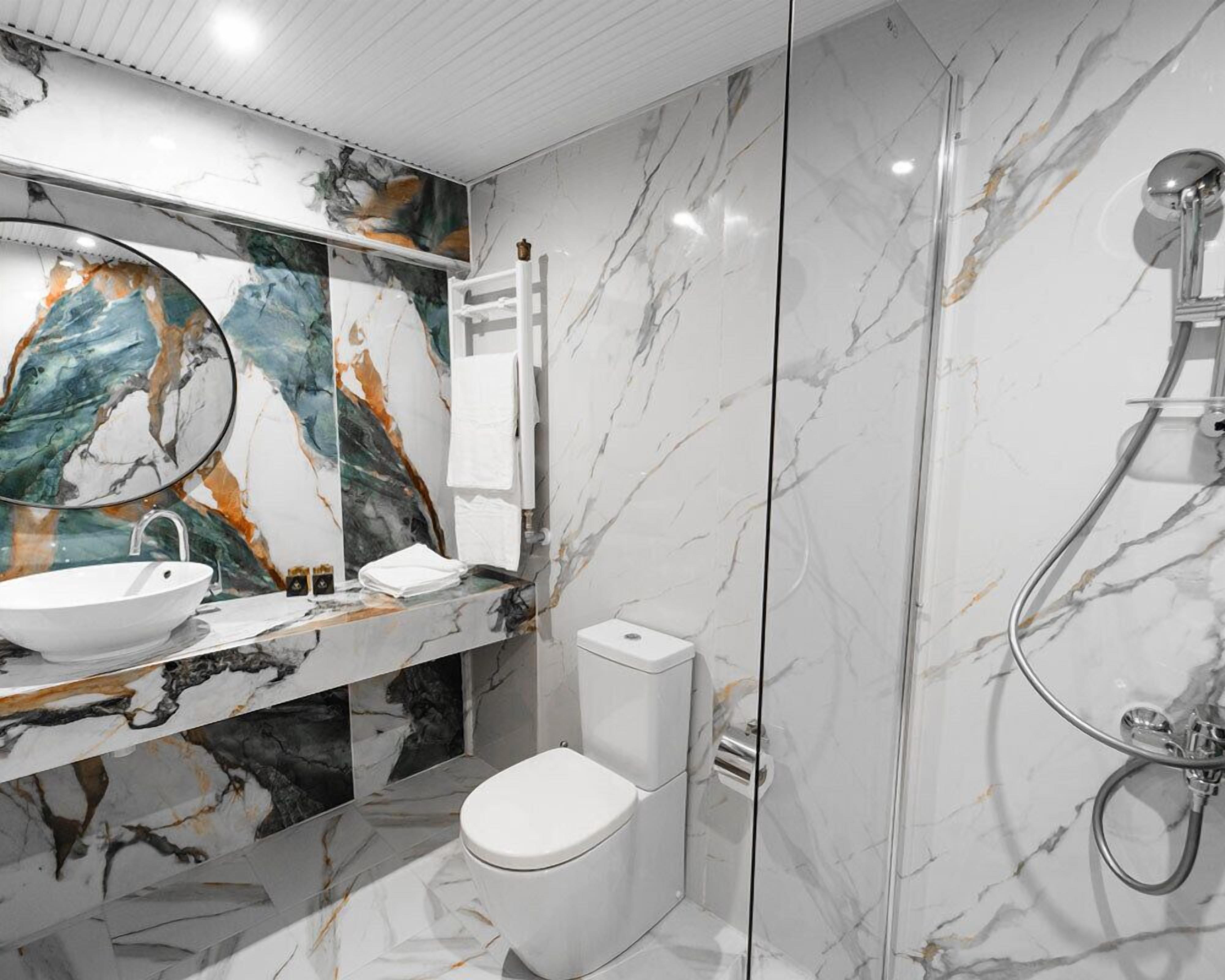 Un baño moderno con tocador de mármol, inodoro y ducha.