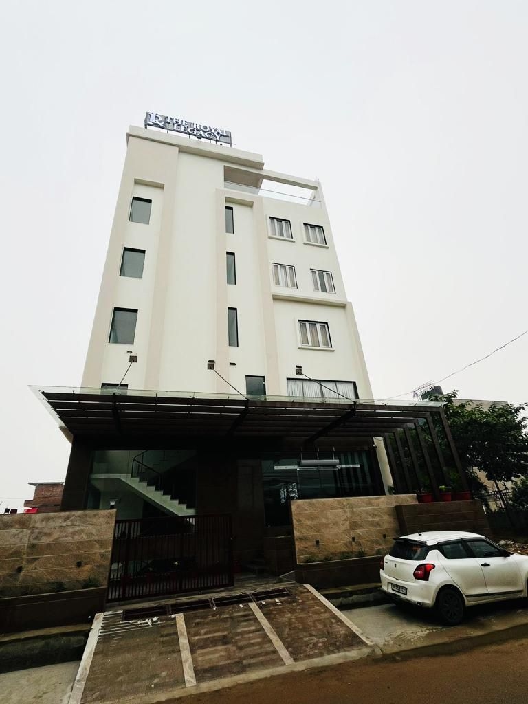 Ein mehrstöckiges Hotel mit modernem Design, das durch eine auffällige Beschilderung an der Spitze gekennzeichnet ist.