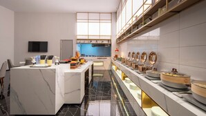 A modern kitchen with marble countertops, a central island, and a long counter with various kitchenware. - World Hotel Qingxian County Cangzhou (Cangzhou)