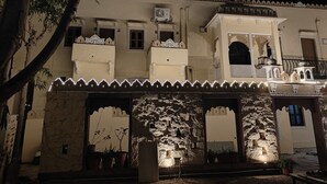Un edificio tradicional con varios balcones, fachada de piedra e iluminación decorativa.