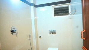 A small bathroom with a toilet, sink, and shower. - SES LINGA COTTAGE (Palayankottai)