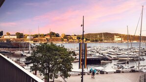 A marina with boats docked, a pedestrian walkway, and a view of buildings in the background. - 2br on Tjuvholmen with sea view (Oslo)