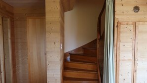 Un interior de fusta amb una escala que condueix a una porta.