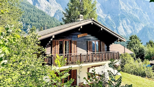 A wooden chalet with a balcony, surrounded by lush greenery and mountains in the background. - Stunning private villa for 6 guests with WIFI, TV and terrace (Les Vérines (chamoson))