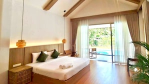 Un dormitorio amplio con una cama grande, cabecera de madera y vista a una piscina a través de un ventanal corredero.