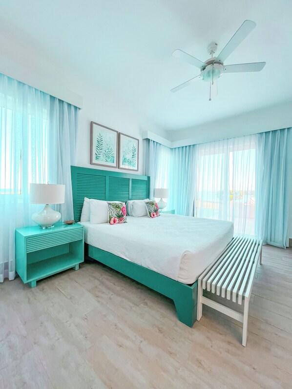 A bedroom with a bed, nightstands, a ceiling fan, and a bench.