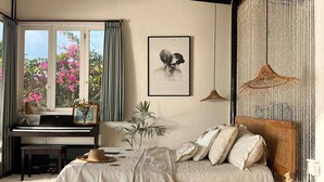 A bedroom with a bed, a piano, a framed picture, and a window with curtains. - Villa Deeksha tropicale ocean view Bingin (Bingin Kuta Selatan)
