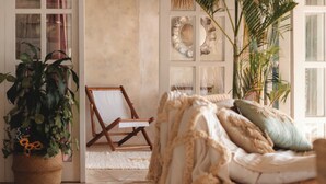 A cozy room with a large potted plant, a wooden easel, and a comfortable sofa with cushions. - Villa Deeksha tropicale ocean view Bingin (Bingin Kuta Selatan)
