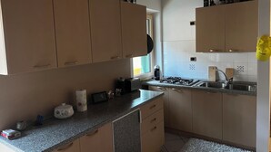 Une cuisine dotée de meubles en bois, d’un plan de travail en granit, d’un évier et de divers appareils de cuisine.
