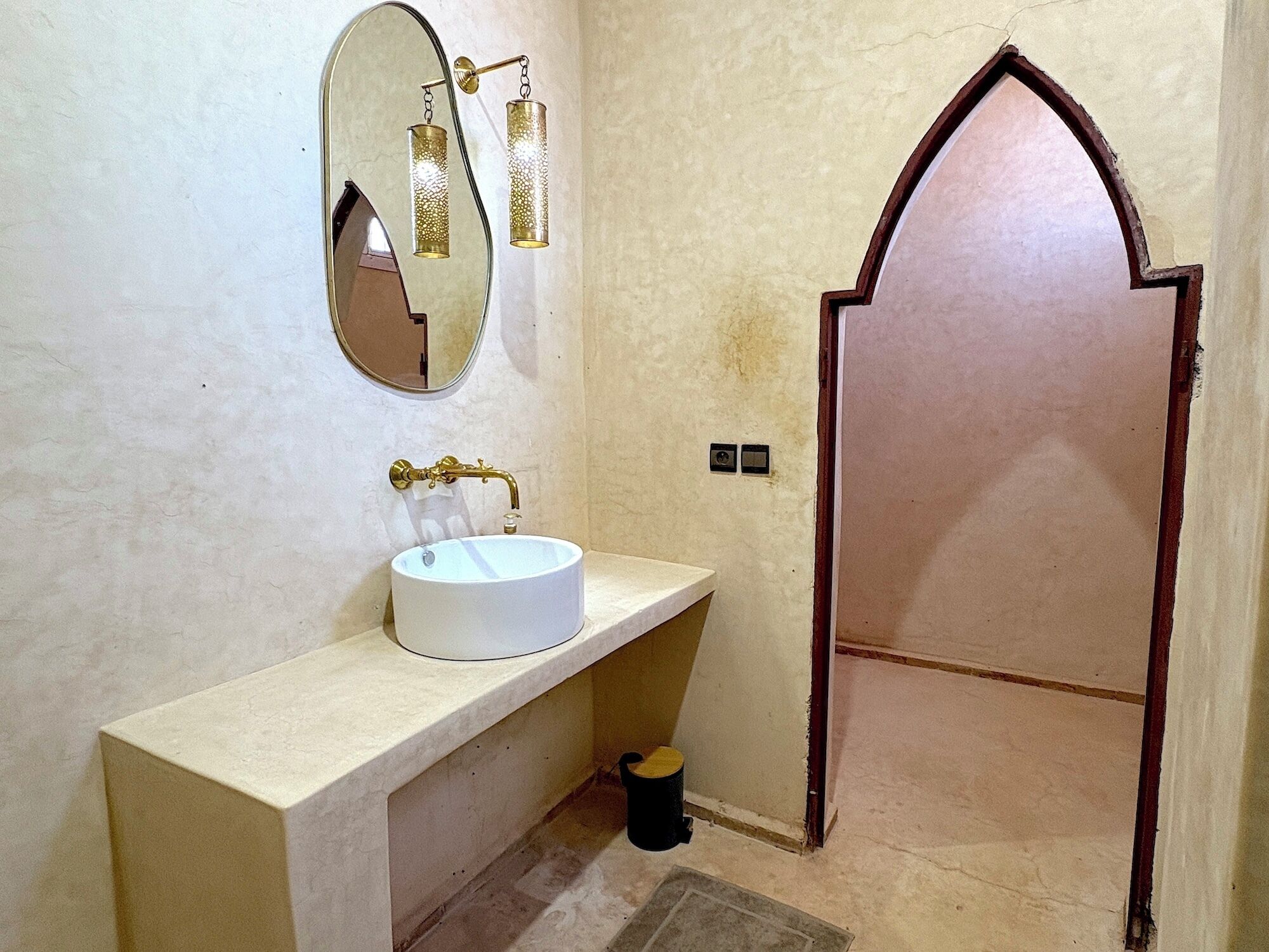 Un baño con un lavabo blanco, un espejo y una puerta.