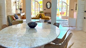 A spacious room with a marble table, wicker chairs, and a yellow sofa. - Palais Bohemia (Zouhria)