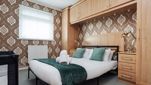 A neatly arranged bedroom with a bed, bedside tables, and a wardrobe. - Boutique 3bd Opposite Etihad & Coop - Free Parking (Greater Manchester)
