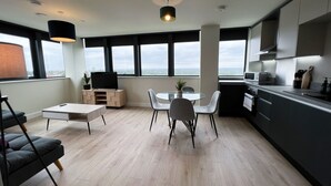 Une cuisine moderne avec un coin repas, de grandes fenêtres et une vue sur la ville.