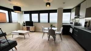 Une cuisine moderne avec un coin repas, de grandes fenêtres et une vue sur la ville.