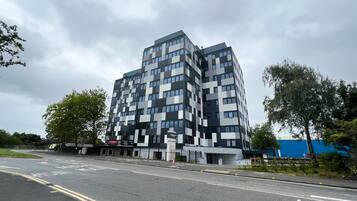 Ein modernes Gebäude mit einer geometrischen Fassade, mehreren Stockwerken und einem flachen Dach.