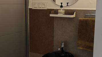 A bathroom with a round mirror, a sink, and a towel rack.