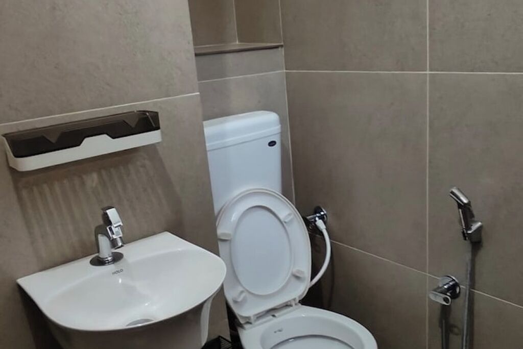 Een badkamer met een wit wastafel, toilet en douche.