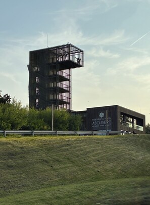 Un edificio moderno con una estructura de torre singular y un anexo de techo plano.