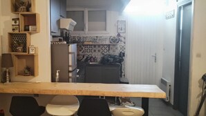 A compact kitchen with a wooden counter, chairs, and a small dining table. - Seafront apartment. All on foot (Saint-Cyprien)