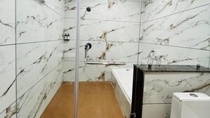A bathroom with a glass-enclosed shower, a bathtub, and a sink. - Basotel Hotel Indore (Indore)
