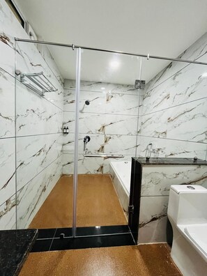 Junior studio suite | Badkamer | Een aparte badkuip en douche, pantoffels, handdoeken, zeep