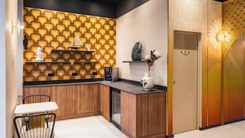 Una cocina moderna con encimera de madera, lavavajillas integrado y una pared decorativa con un diseño geométrico.