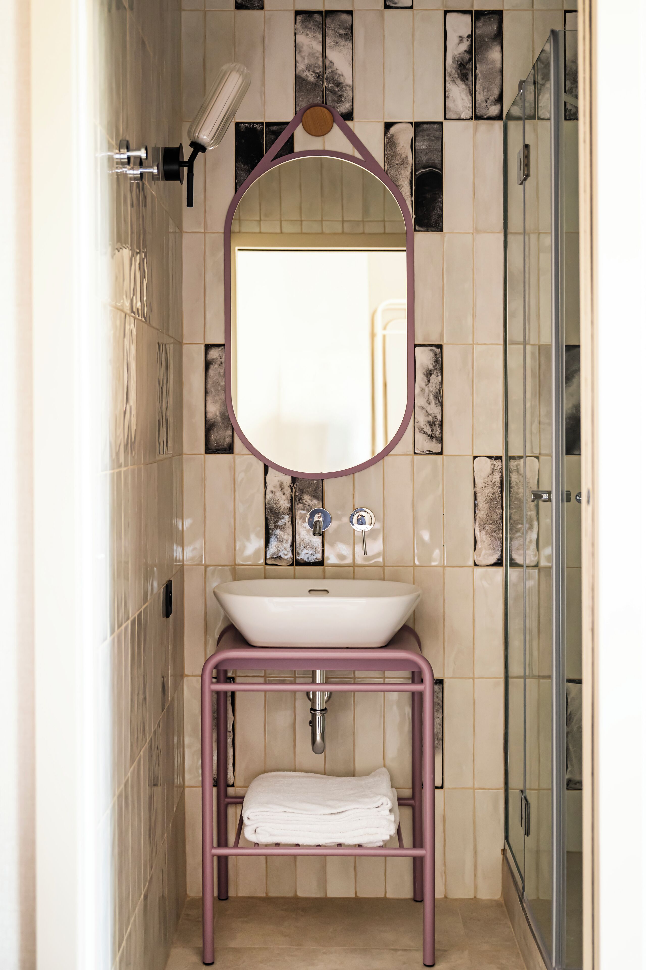 A bathroom with a white sink, a mirror, and a glass shower enclosure.
