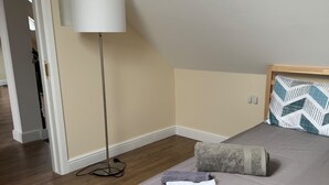 A bedroom with a bed, a floor lamp, and a door leading to another room. - Close Central London 1 bed Apartment Sleeps 3 (London)