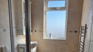 A bathroom with a toilet, sink, and a window. - Close Central London 1 bed Apartment Sleeps 3 (London)