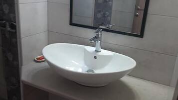 A bathroom with a white sink, a mirror, and tiled walls.