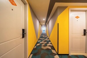 A hotel corridor with a check-in desk, a reception area, and a door with a sign. - Boke Inn (Jing'an Branch, Nanjing West Road, Shanghai) (Shanghai)