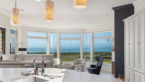 A modern kitchen with a large window, a sink, and a chair.
