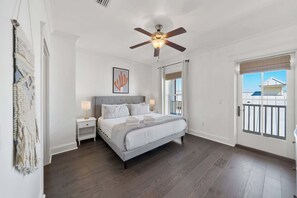 A bedroom with a bed, nightstands, a ceiling fan, a window with curtains, and a view of the outside. - New Downtime Prominence 30A Lux, Pet Friendly, LSV, Bikes (Panama City Beach)