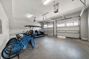 Eine geräumige Garage mit einem blauen Fahrrad und einem Golfwagen.