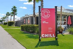A red sign for 'Chill Love' with a logo, text about live music, sports, movies, and food/drinks, and a pet welcome sign.