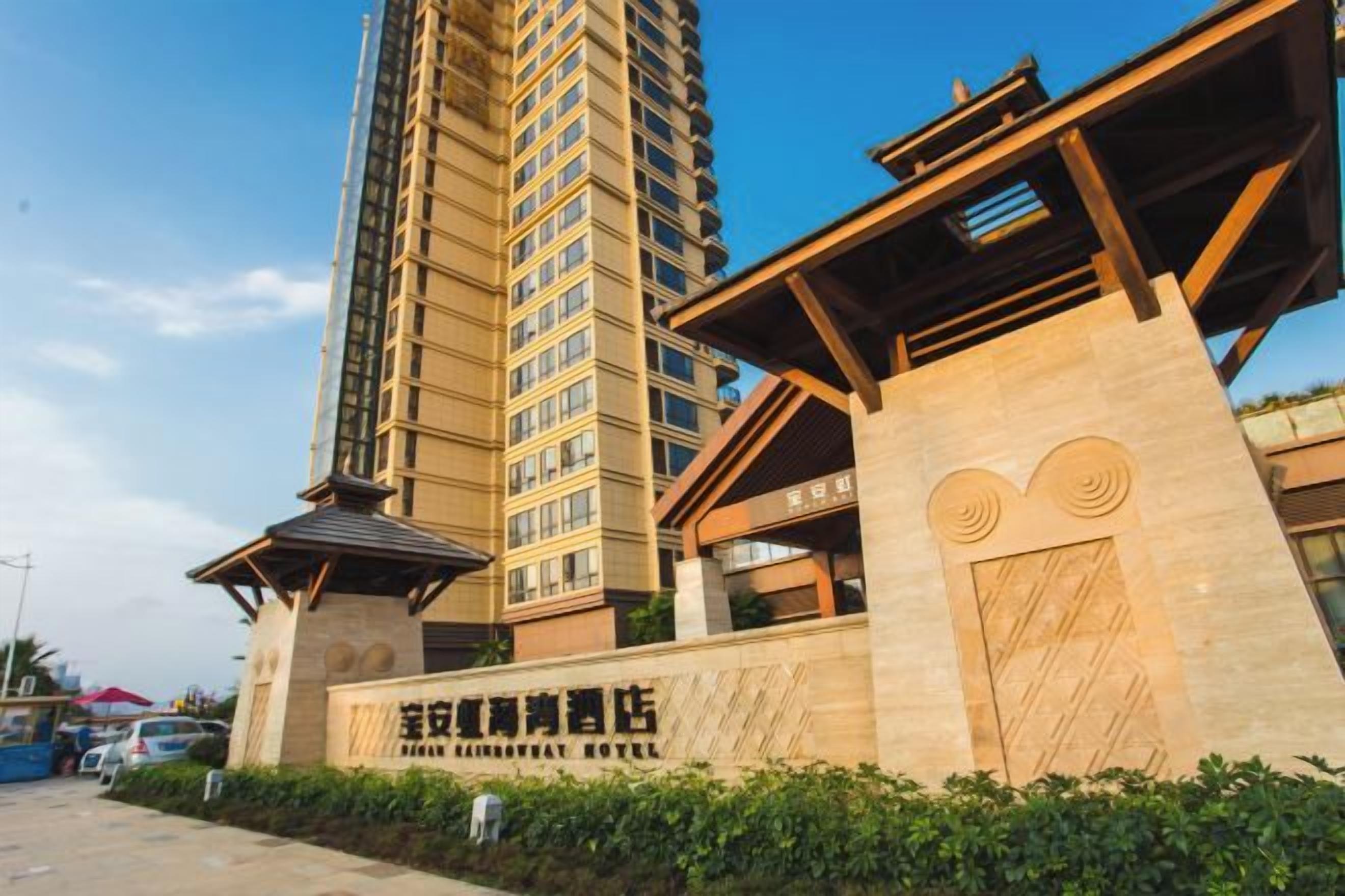 A tall hotel building with a prominent entrance and a sign indicating it is the 'Shenzhen Guangda Hotel'.