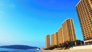 A beach with high-rise buildings in the background. - Bao'an Rainbow Bay Hotel (Huidong)