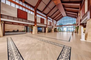 A spacious lobby with high ceilings, large windows, and a patterned carpet.