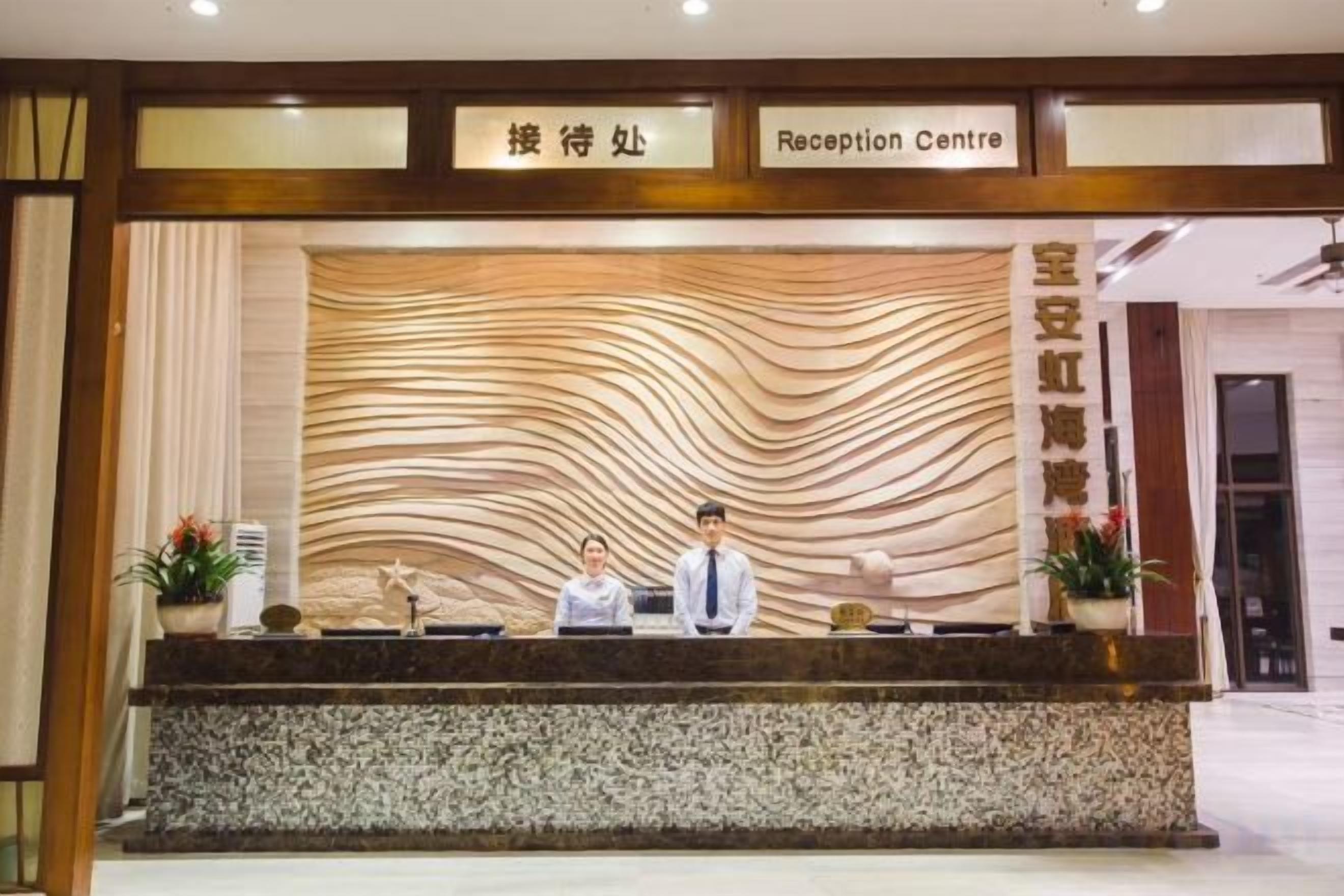 Un mostrador de recepción con diseño moderno, una placa identificativa y un área de espera.
