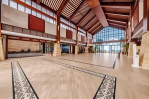 Un hall d’entrée spacieux, doté de hauts plafonds, de grandes fenêtres et d’un tapis à motifs.