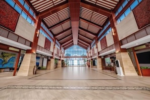 A spacious lobby with high ceilings, large windows, and a central open area.