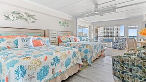 A spacious bedroom with two beds, a balcony, and a view of the city. - Bright Oceanfront Studio | Sleeps 4 w/ Pool Access (Ocean City)